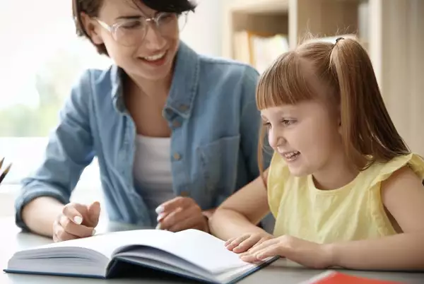 reading partner with child reading smiling