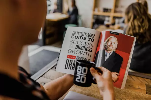 An entrepreneur reading a book about market research and sampling