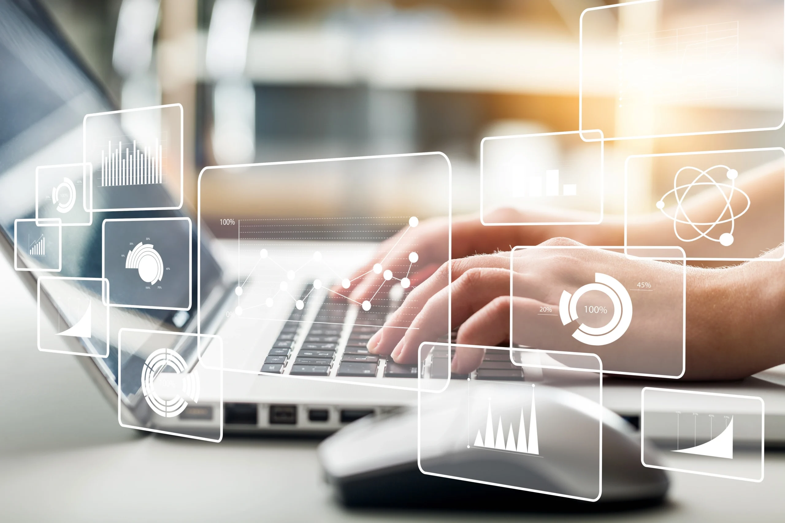 A stock image of someone typing on a computer with holographic graphs